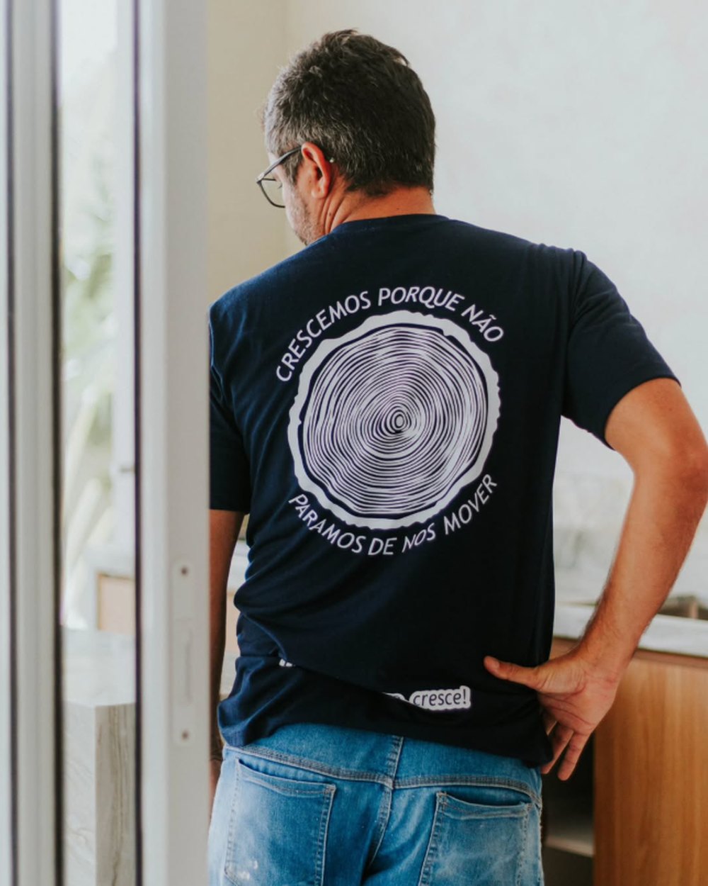 Marceneiro da Commuto com a camisa da equipe, estampada com os anéis de tronco